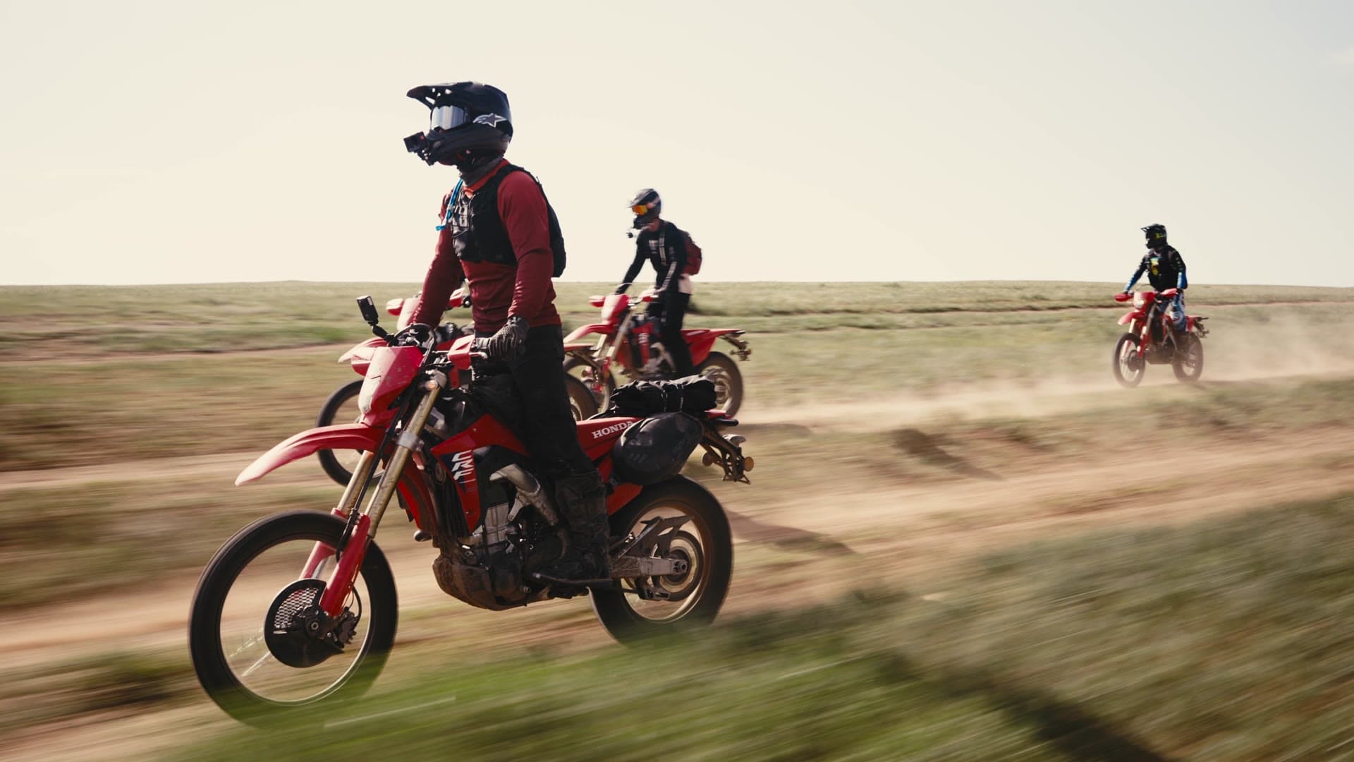 Two riders on Honda CRF450RL motorcycles crossing the Mongolian steppe